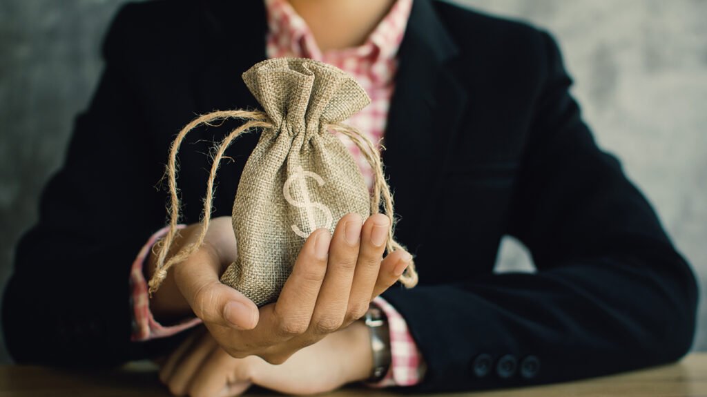 Businessman with a bag of money, symbolizing financial success and investment.